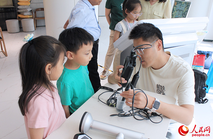 工作人员给孩子们展示环境监测设备。人民网记者 张静淇摄